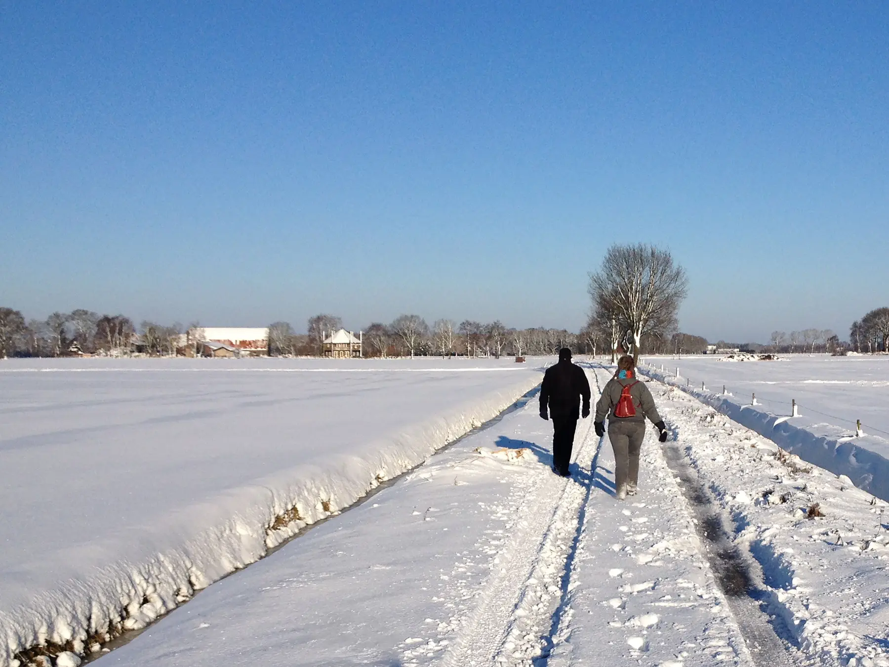 Wandelaars op een besneeuwd landpad